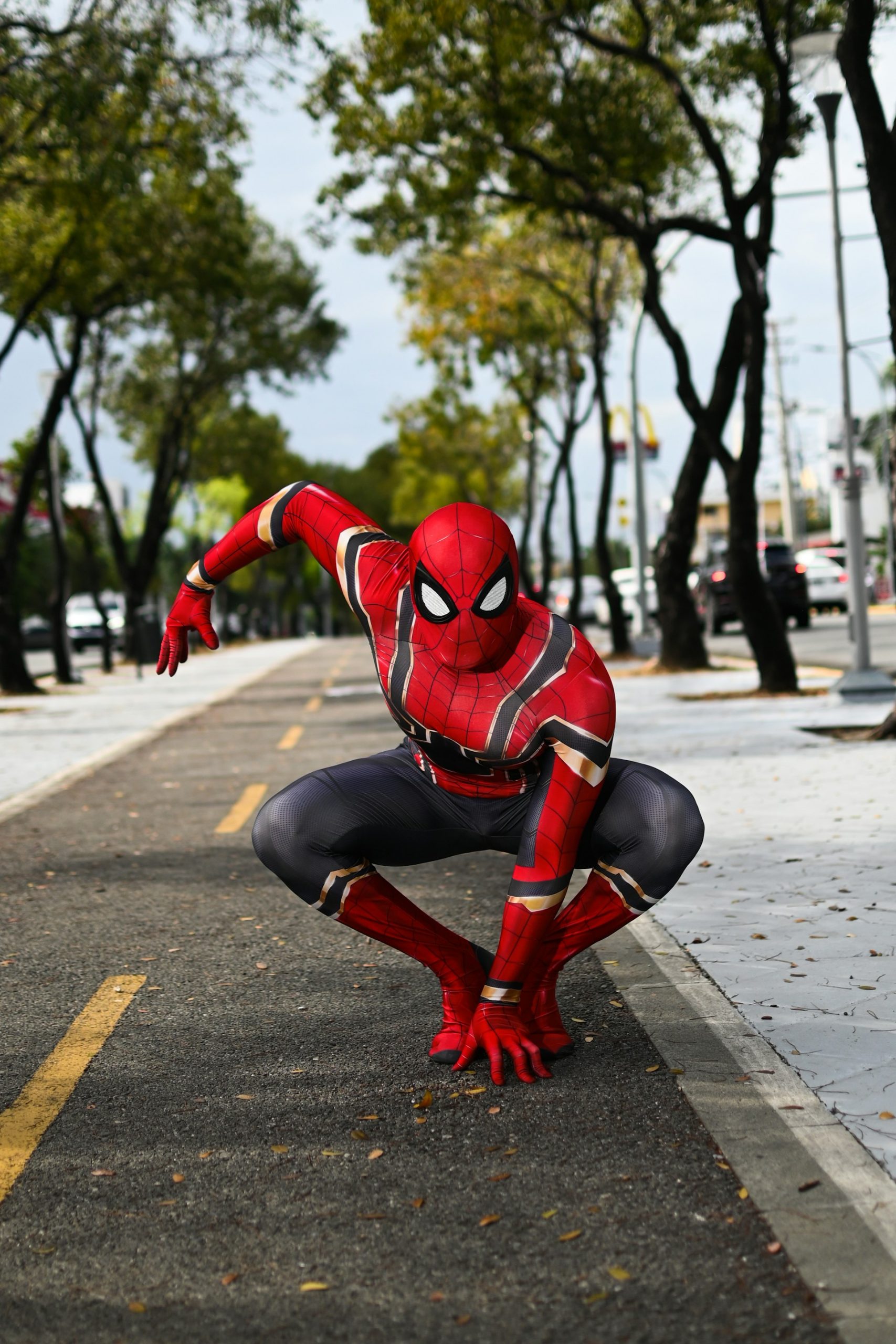 Spider-Man crouched in a ready-for-action pose on a quiet urban street