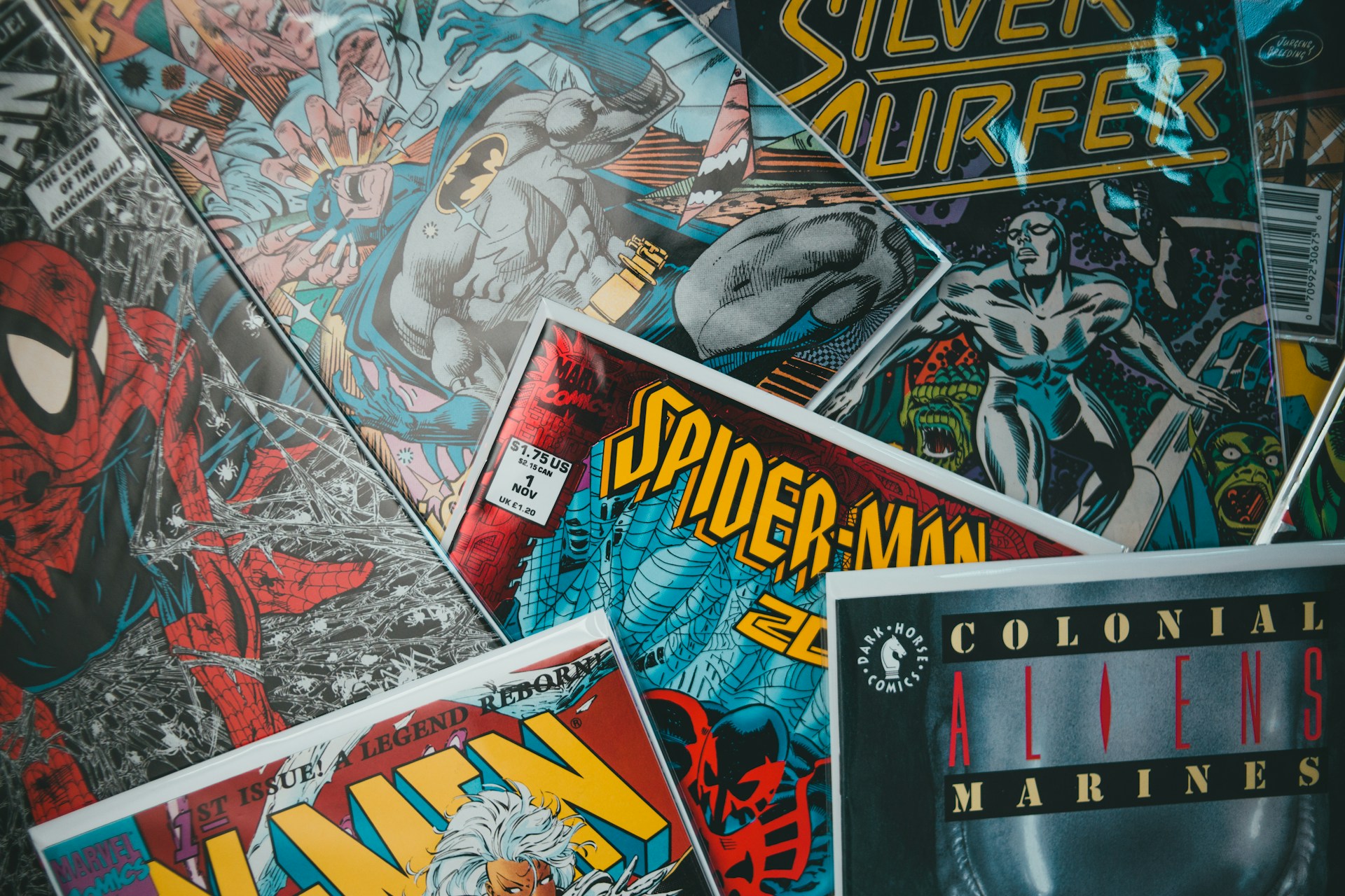 A pile of comic books, including visible Spider-Man covers, stacked slightly askew